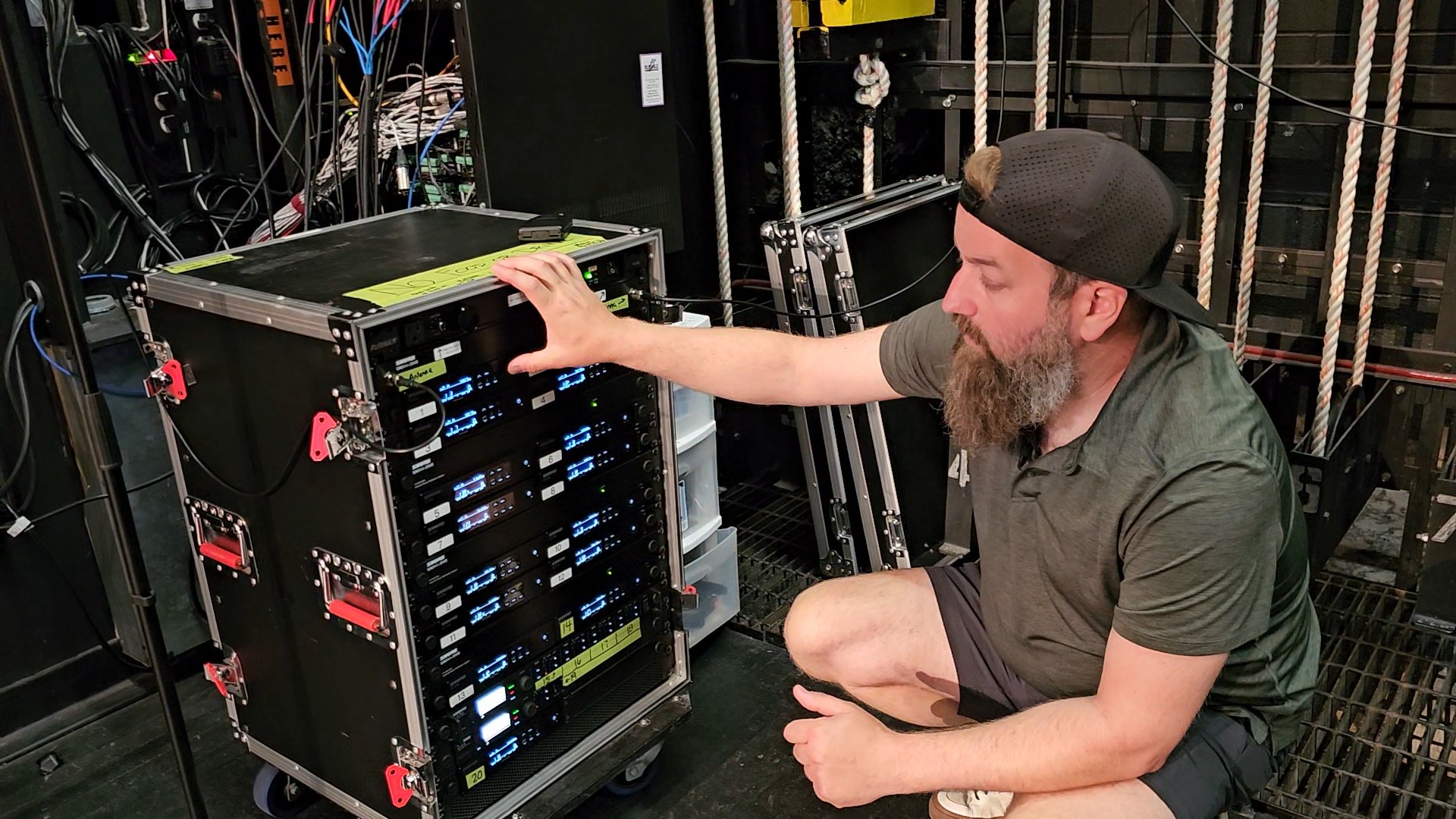 Kleintech technician servicing a wireless microphone rack backstage